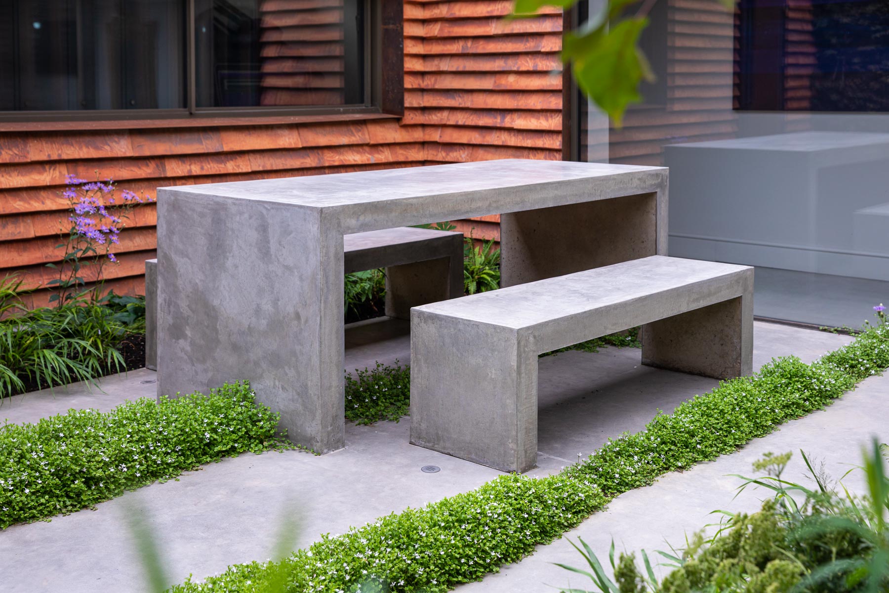 Colm Joseph Cambridge garden design modern courtyard concrete furniture table and benches planted concrete paving joints pratia treadwellii